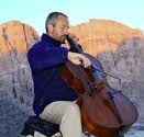 uomo che suona il violoncello in montagna