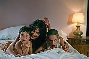 donna su letto con due bambini