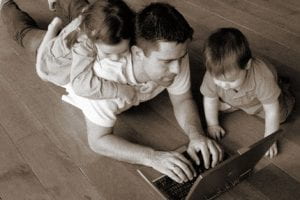 Padre con due bambini lavora al computer